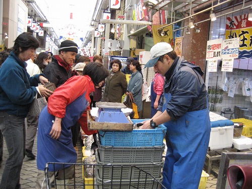 魚の棚のお店の前で売られる「いかなご」に人が集まっています